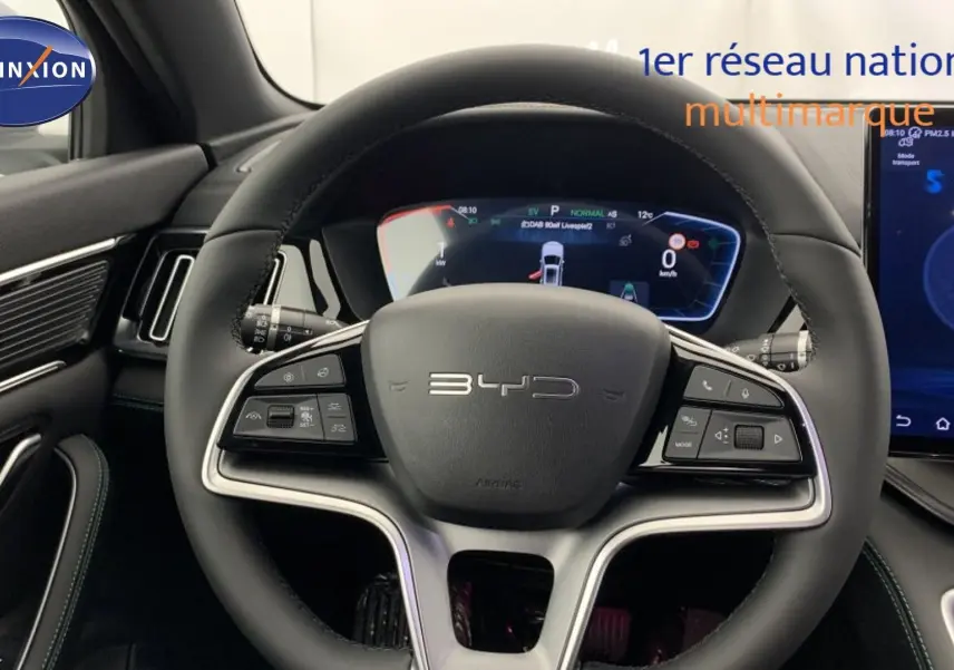 Vue intérieure avant du BYD SEAL U 2025 avec tableau de bord noir et sièges beige à surpiqûres orange.