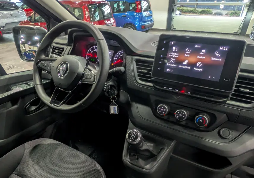 Intérieur du Renault Trafic Combi 2023 vu côté conducteur, tableau de bord noir avec écran tactile et levier de vitesse manuel.