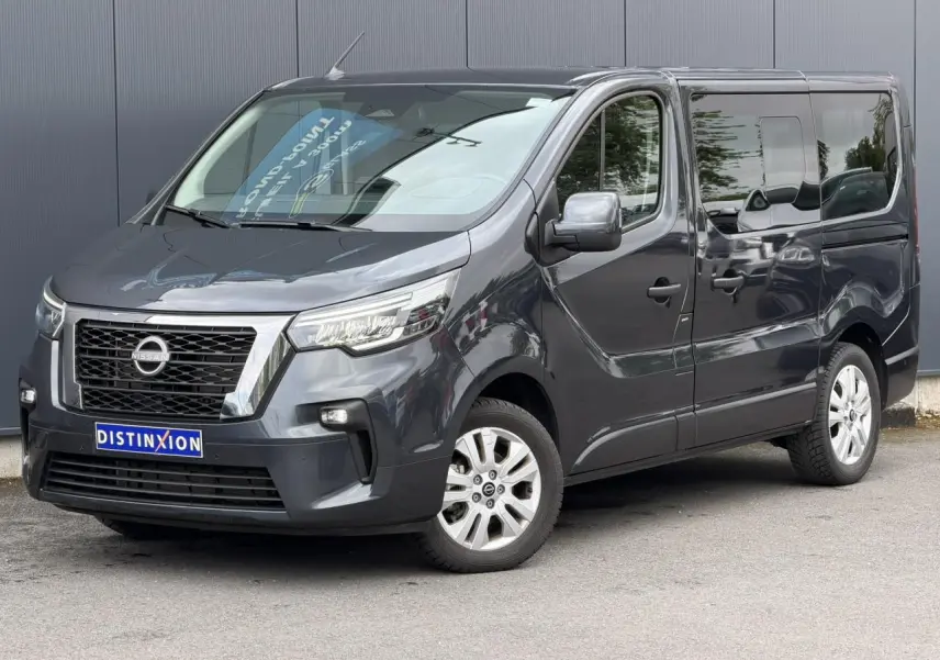 Vue 3/4 avant droit du Nissan Primastar Combi gris Comète avec hayon vitré et jantes alliage 17 pouces.