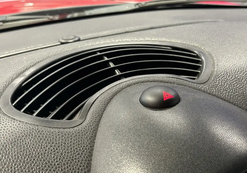 Détail intérieur du tableau de bord en carbone et cuir rouge de la MINI Cabriolet Cooper S 2012 vue côté passager.