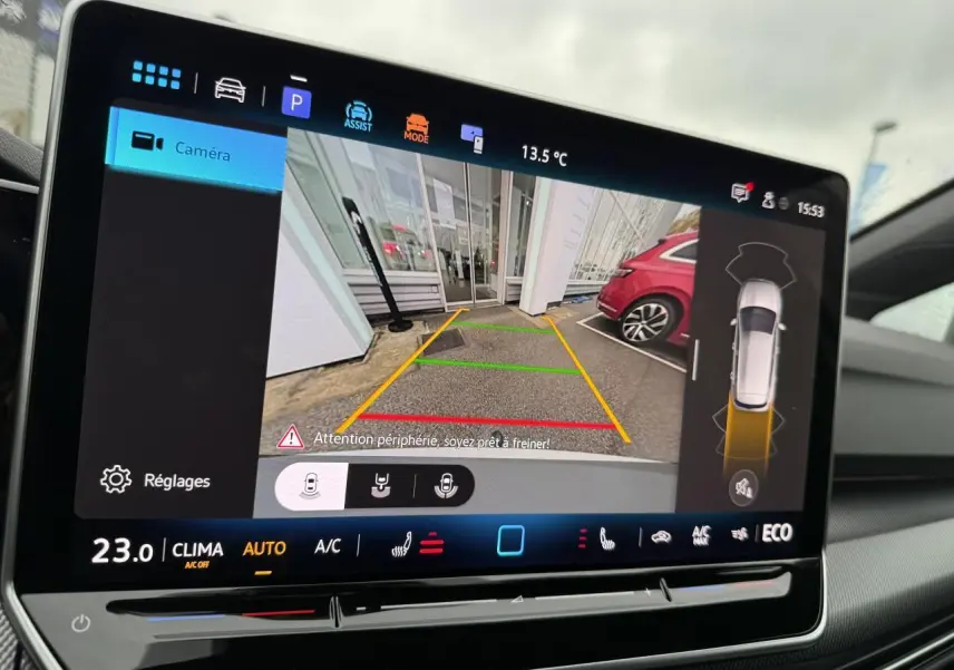 Écran central montrant la caméra de recul d'une Volkswagen Golf 1.5 eHybrid blanche, avec guidage de stationnement.