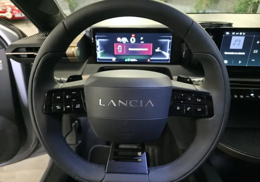 Volant sport Lancia Ypsilon 2025 vu de face, avec commandes intégrées et tableau de bord numérique lumineux.