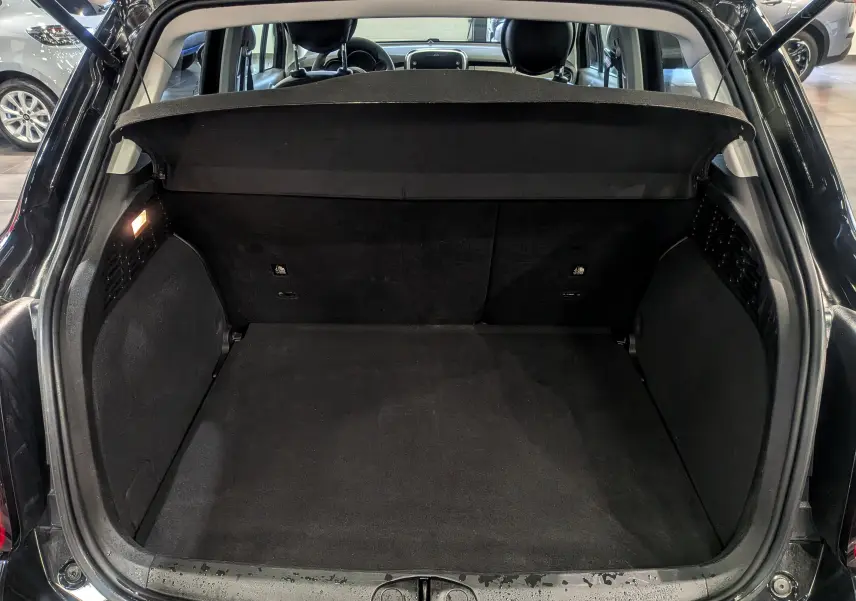 Coffre ouvert vu de l'arrière d'une FIAT 500X 2024 noir cinéma, montrant un espace de chargement vide et propre.