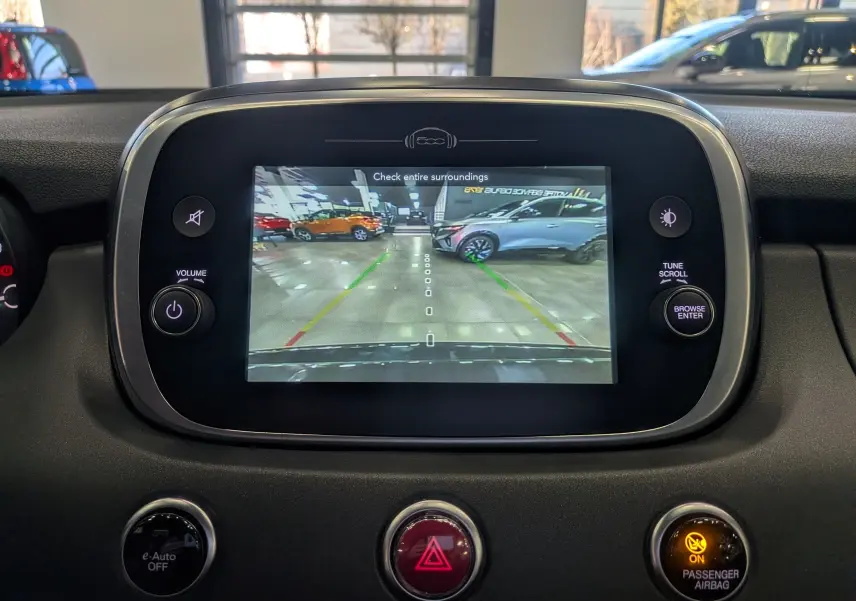 Écran central de la Fiat 500X 2024 montrant la caméra de recul avec interface noire et commandes autour.