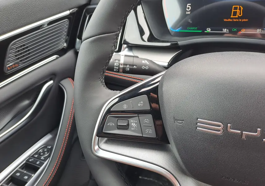 Gros plan sur le volant noir avec commandes multifonctions et tableau de bord numérique du BYD SEAL U 2025.