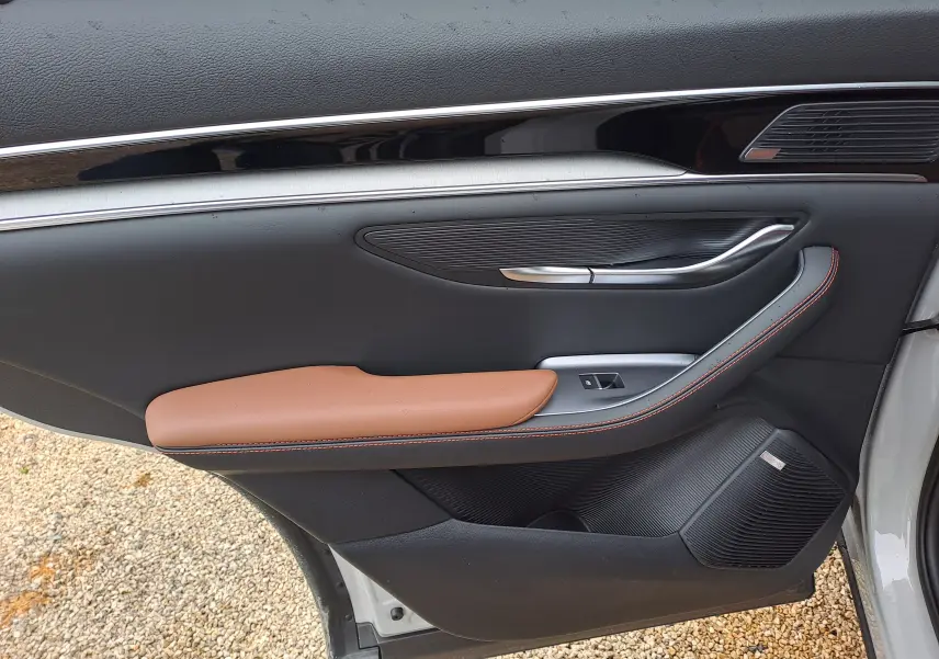 Vue côté gauche de la porte avant d’une BYD SEAL U 2025 BOUNDLESS CLOUD, avec accoudoir marron et détails noirs.