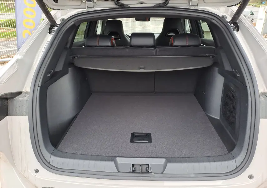 Coffre ouvert vu de l'arrière du BYD SEAL U 2025 couleur Boundless Cloud avec cache-bagages et sièges arrière noirs.