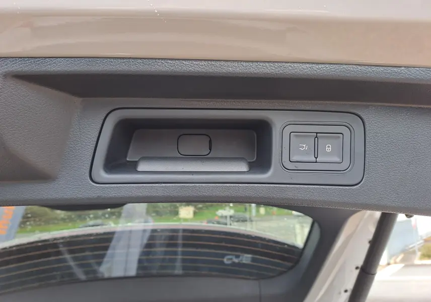 Gros plan sur la poignée intérieure et les boutons de verrouillage du hayon du BYD SEAL U couleur Boundless Cloud.