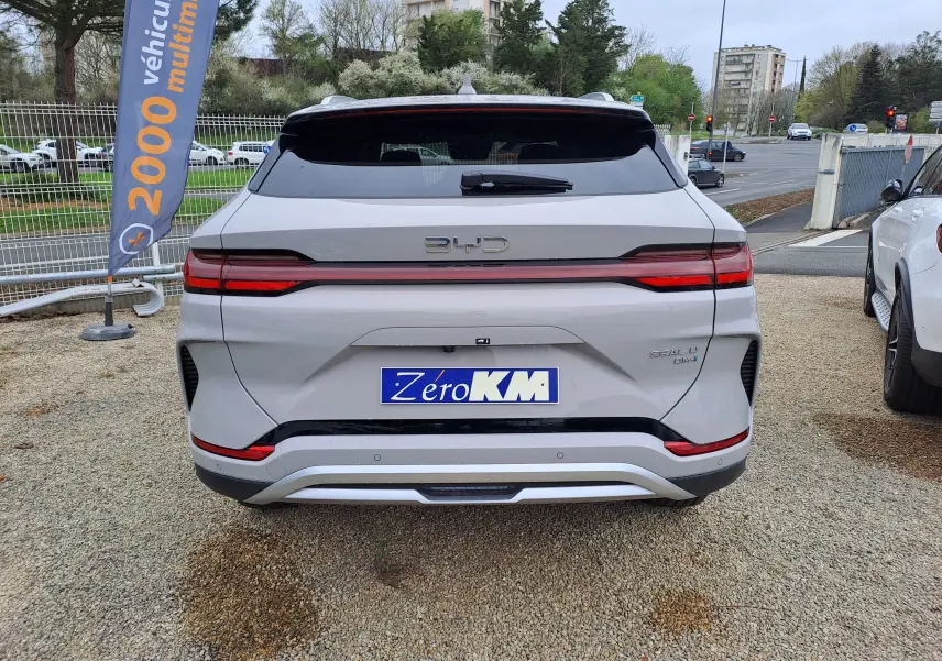 Vue arrière d'un BYD SEAL U hybride rechargeable couleur Boundless Cloud avec feux LED et logo BYD lumineux.