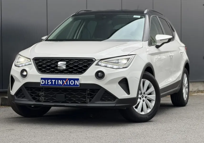 SEAT Arona TSI 115 DSG Style blanc en 3/4 avant droit avec calandre noire et jantes alliage 16 pouces.
