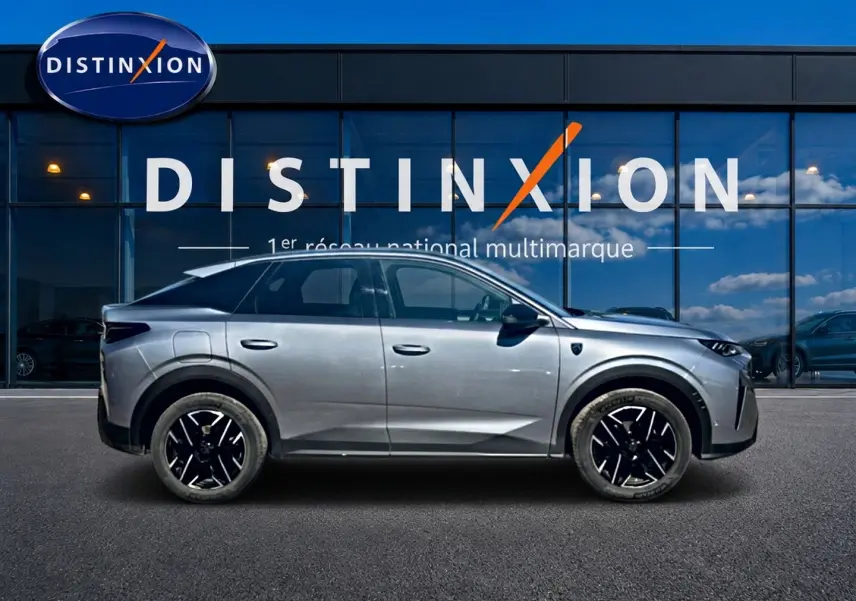 Profil côté gauche du Peugeot 3008 gris 2025 avec jantes alliage noires devant une vitrine Distinxion.