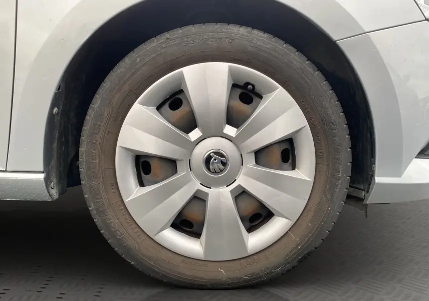 Gros plan sur la roue avant droite gris argent d'une Skoda Fabia 2021 avec enjoliveur et logo central visible.