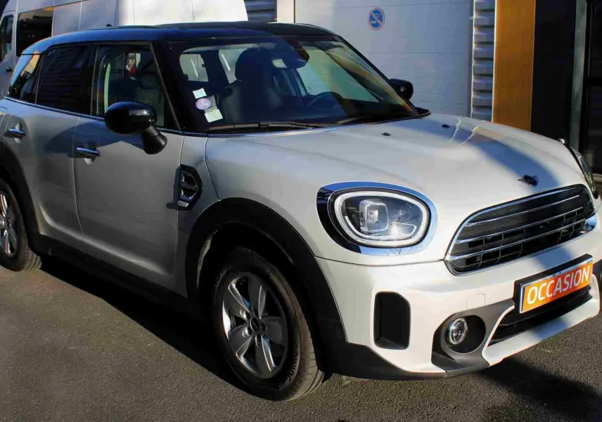 MINI Countryman gris perle avec toit noir, vue 3/4 avant droit, calandre et phares LED visibles.