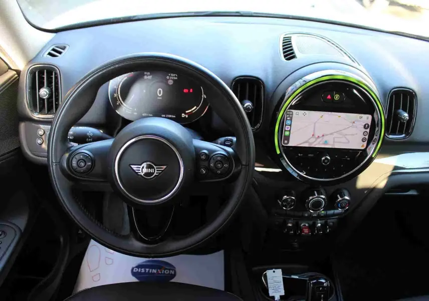 Vue intérieure du tableau de bord de la MINI Countryman gris perle, avec volant noir et écran central tactile éclairé.