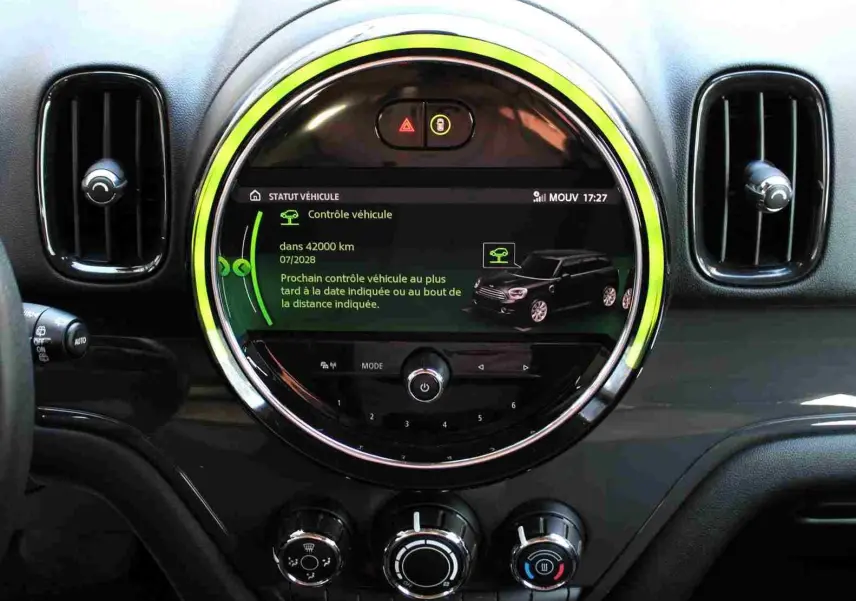 Vue rapprochée du tableau de bord du MINI Countryman 2020, écran central rond avec interface digitale et cerclage lumineux vert.