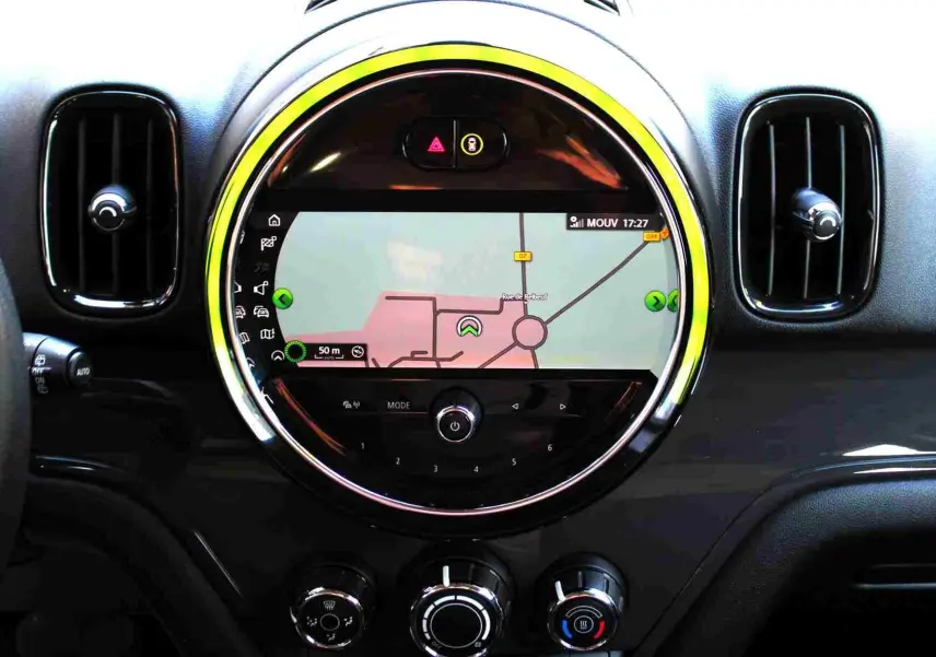 Vue rapprochée du tableau de bord du MINI Countryman 2020 avec écran de navigation circulaire et éclairage jaune autour.