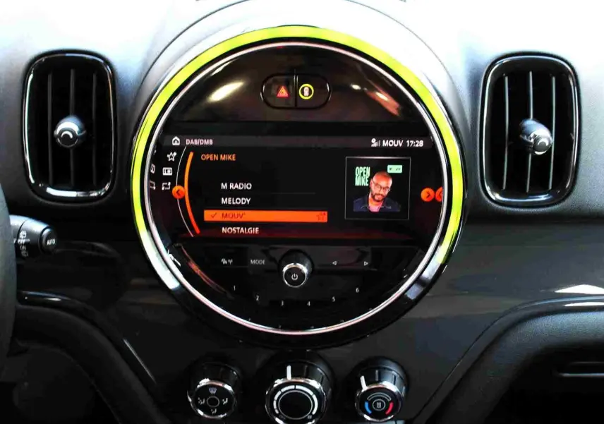 Vue rapprochée du tableau de bord du MINI Countryman gris perle, mettant en valeur l’écran central circulaire avec interface multimédia.