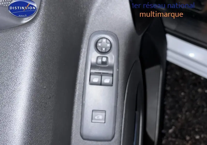 Gros plan sur la commande des vitres électriques côté conducteur du Citroën Berlingo Fourgon blanc, porte ouverte.