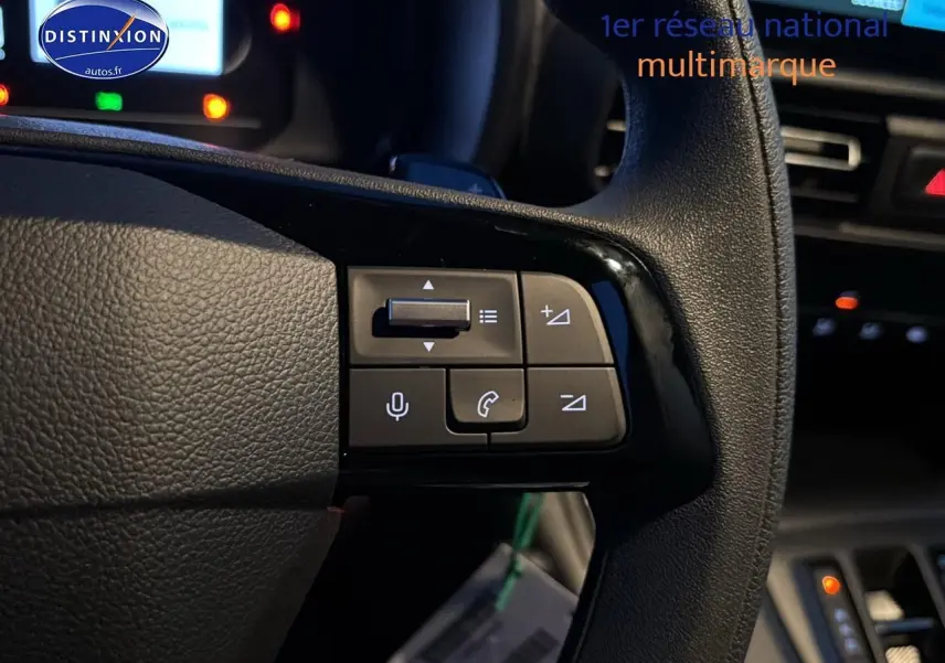 Gros plan sur le volant multifonction noir du Citroën Berlingo Fourgon blanc, avec commandes audio et téléphone visibles.