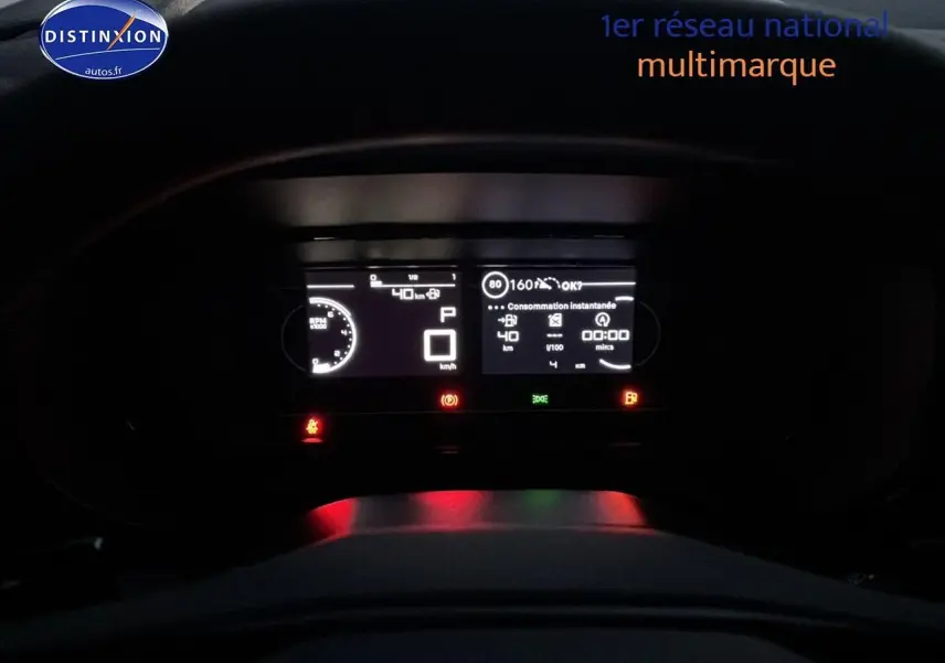 Vue rapprochée du tableau de bord numérique du Citroën Berlingo Fourgon blanc, affichant la vitesse et la consommation.