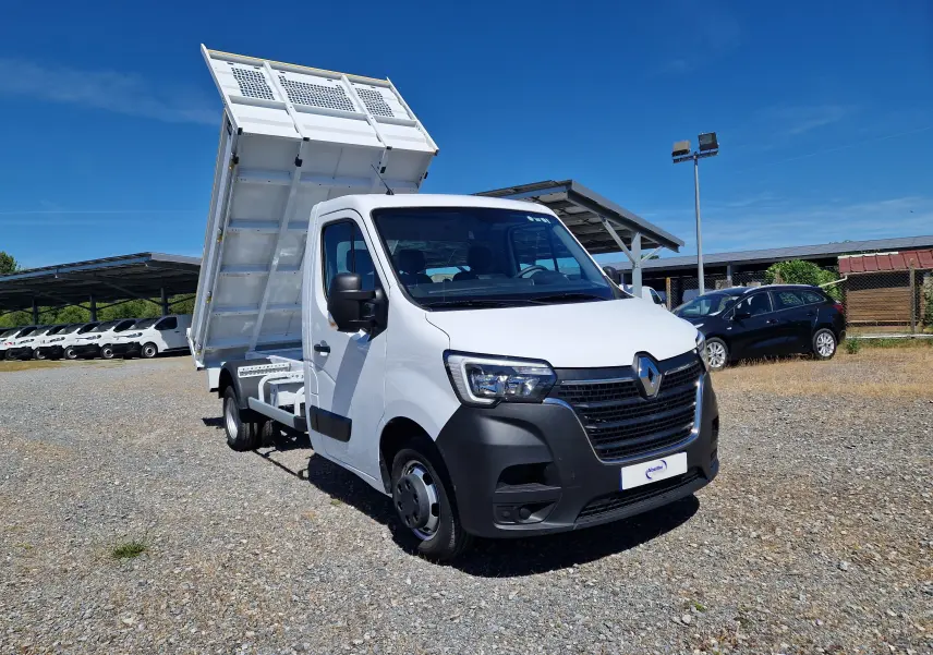 Renault Master Châssis cabine blanc en 3/4 avant droit avec benne basculante relevée et roues jumelées visibles.
