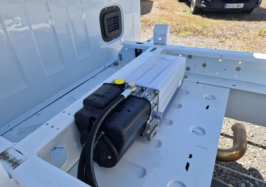 Vue rapprochée du châssis blanc du Renault Master Benne L2, mettant en valeur un composant mécanique noir et métallique.