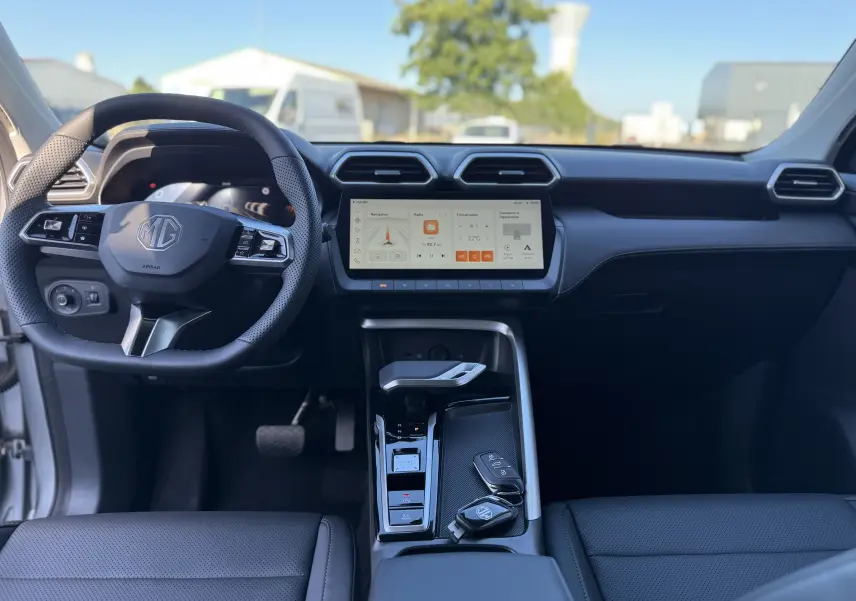 Vue intérieure avant du tableau de bord du MG ZS 1.5 L Hybrid+ 2026 en cuir noir avec écran tactile central et volant multifonction.