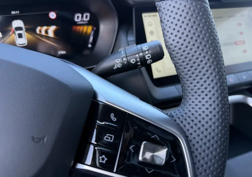Gros plan sur le volant perforé et les commandes multifonctions du MG ZS 1.5 L Hybrid+ 2026, intérieur noir.