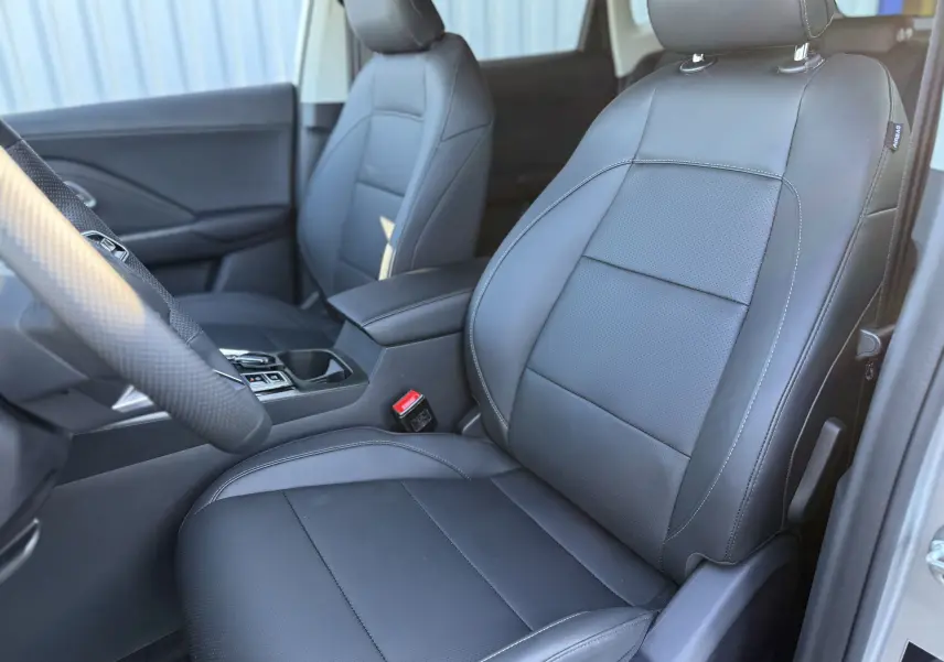 Vue intérieure côté conducteur du MG ZS 1.5 L Hybrid+ 2026 avec sièges en cuir noir et console centrale visible.
