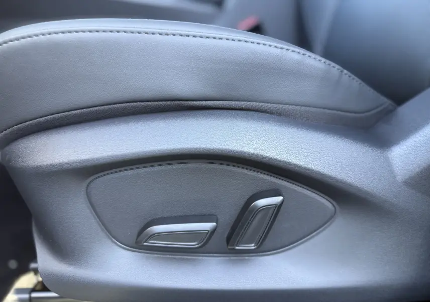 Détail des commandes de réglage électrique sur le côté gauche d’un siège en cuir gris foncé du MG ZS 1.5 L Hybrid+ 2026.