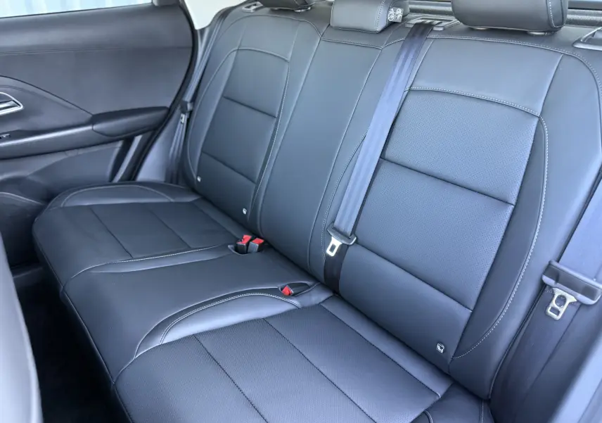 Vue intérieure de la banquette arrière en cuir noir du MG ZS 1.5 L Hybrid+ 2026, côté droit avec ceinture de sécurité visible.