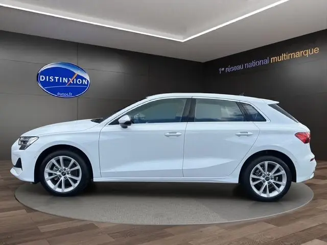 Vue latérale droite d'une Audi A3 Sportback 2024 blanc Arkona avec jantes alliage et vitres teintées, en showroom.