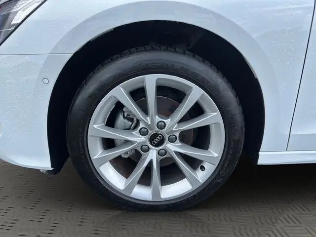 Gros plan sur la roue avant gauche d'une Audi A3 Sportback blanche Arkona avec jante alliage léger à 5 branches doubles.