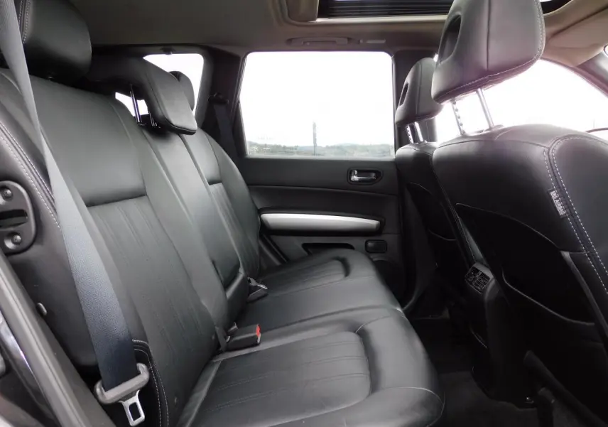 Vue latérale intérieure des sièges arrière en cuir noir du Nissan X-TRAIL 2011 avec toit ouvrant panoramique.