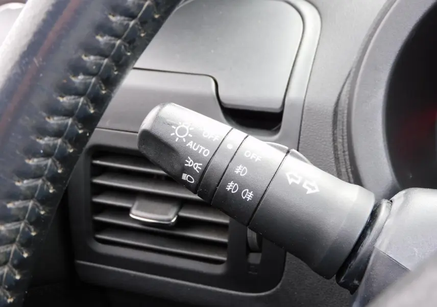 Gros plan sur la commande des phares et clignotants du Nissan X-TRAIL noir, intérieur côté conducteur.