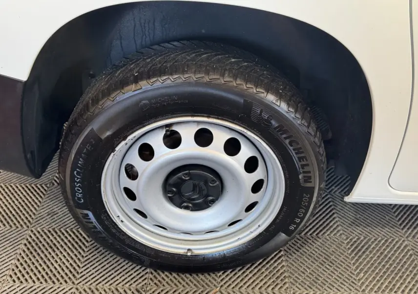 Gros plan sur la roue avant droite en jante acier du Citroën Berlingo blanc de 2020.