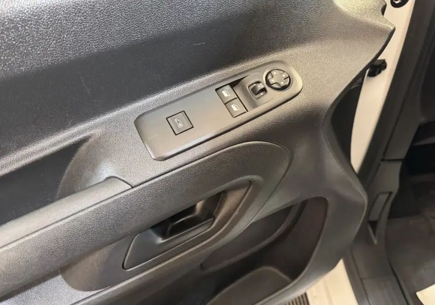 Gros plan sur la porte avant gauche noire avec commandes électriques sur un Citroën Berlingo blanc 2020.