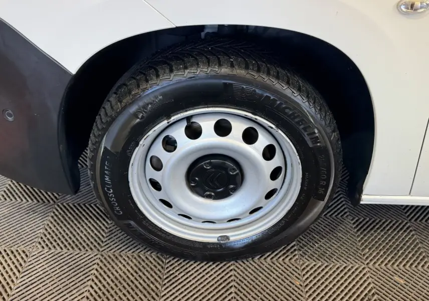 Gros plan sur la roue avant droite en jante acier grise du Citroën Berlingo blanc de 2020.