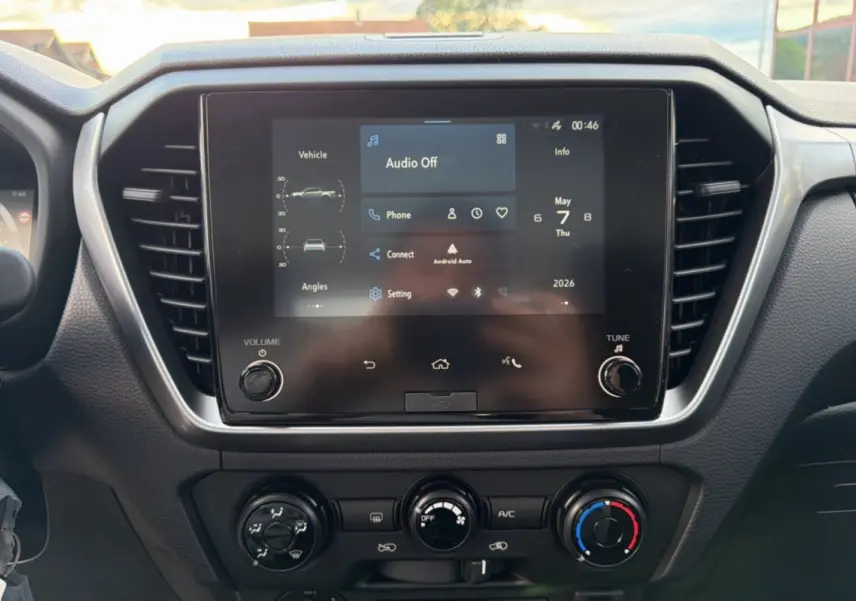 Vue rapprochée de l’écran tactile central du tableau de bord de l’Isuzu D-MAX 2026 avec commandes climatisation.