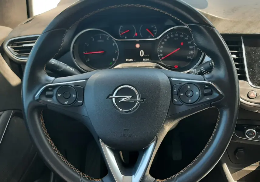 Vue intérieure avant centrée sur le volant noir et la console centrale d'une Opel Crossland X 130ch Innovation 2019.