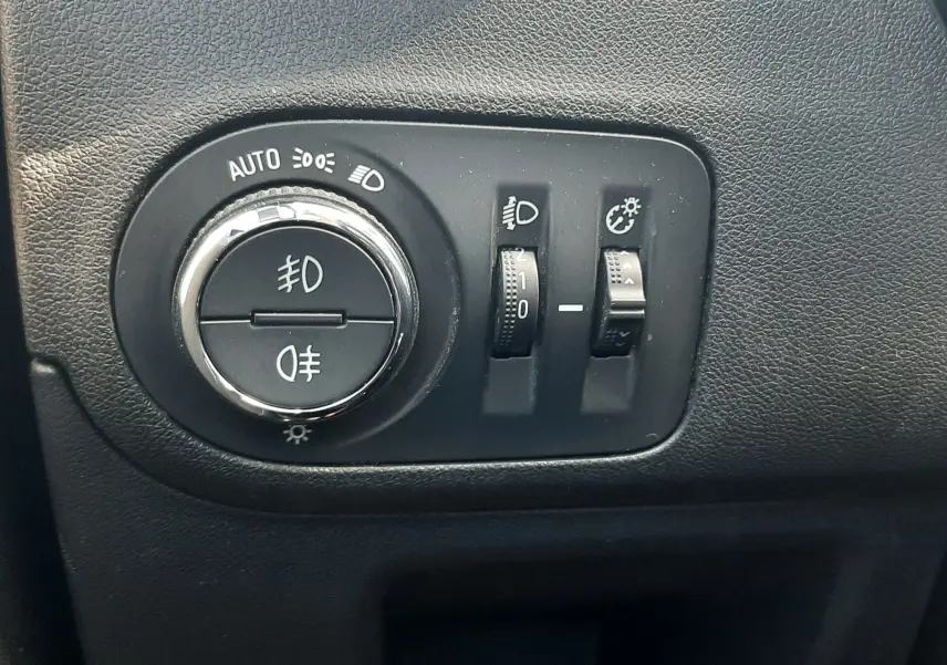 Gros plan sur les commandes des vitres et rétroviseurs côté conducteur de l'Opel Crossland noir avec toit blanc.