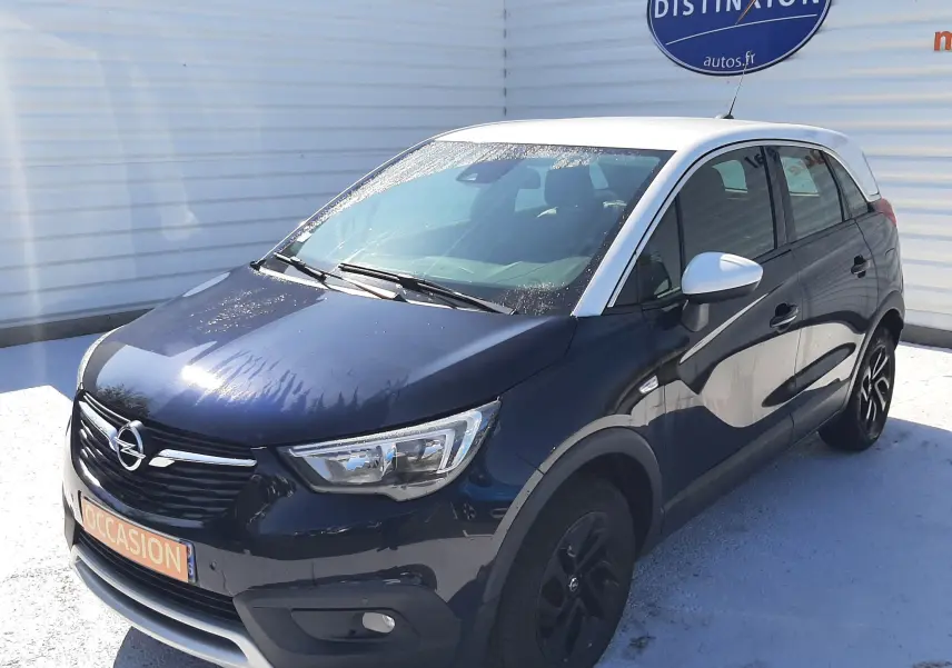 Opel Crossland X 130ch Innovation noir avec toit blanc, vue 3/4 avant droit, stationné devant un mur blanc.