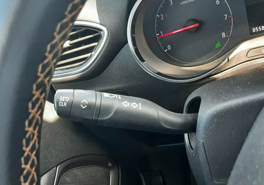 Gros plan sur les commandes du volant côté gauche de l'Opel Crossland noir avec toit blanc, montrant les boutons multifonctions.