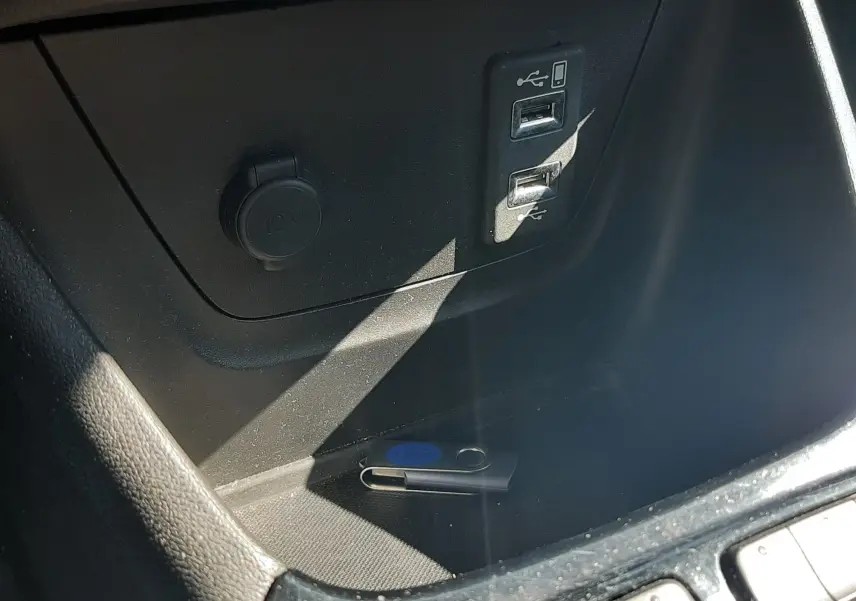 Gros plan sur la console centrale de l'Opel Crossland noir, montrant les boutons de contrôle et le soufflet de levier de vitesse en cuir.