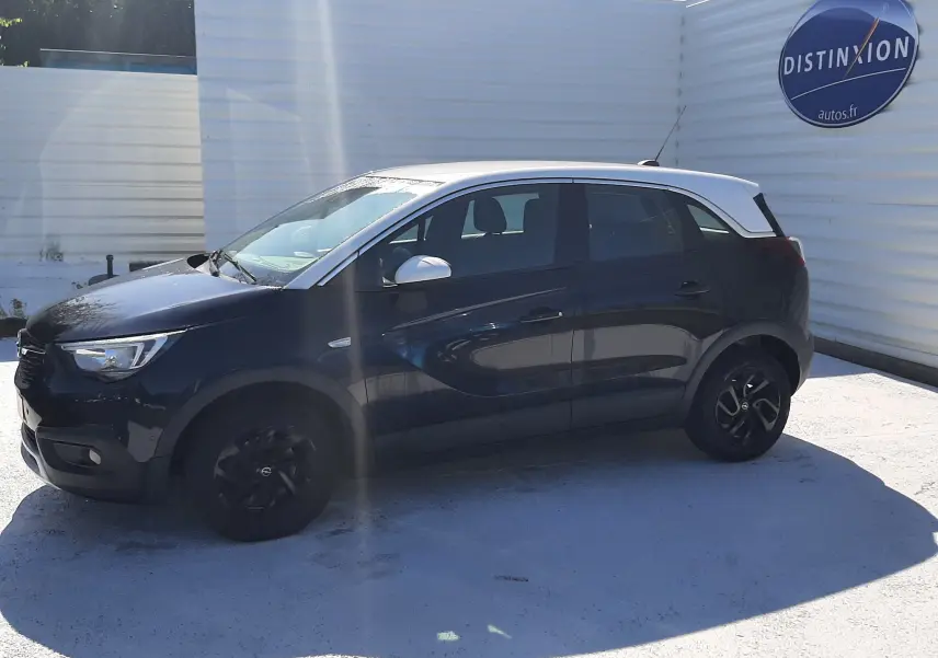 Opel Crossland X 130ch Innovation noir avec toit blanc, vue 3/4 avant droit sur parking extérieur.
