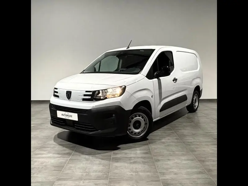 Peugeot Partner XL BlueHDi blanc Icy vu en 3/4 avant droit avec phares allumés sur fond neutre intérieur.