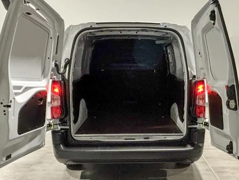 Vue arrière du Peugeot Partner XL blanc Icy avec portes battantes ouvertes montrant l'espace de chargement vide.