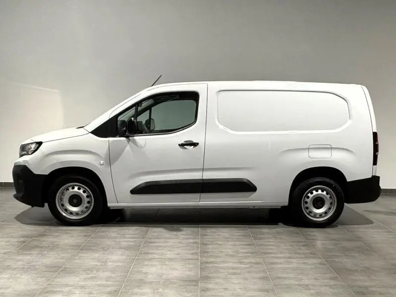 Profil droit du Peugeot Partner XL blanc Icy avec porte latérale coulissante et jantes acier simples.