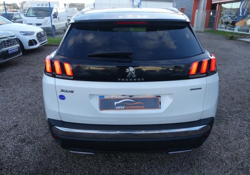 Vue arrière d'un Peugeot 3008 blanc nacré avec feux arrière à trois griffes et bandeau noir brillant.