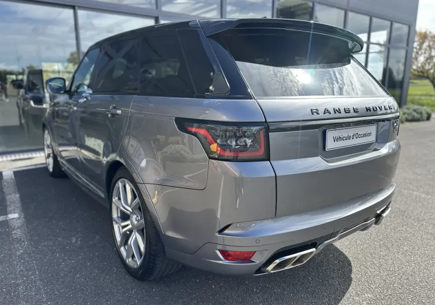 Vue 3/4 arrière droite du Range Rover Sport gris foncé avec double sortie d'échappement et toit noir brillant.
